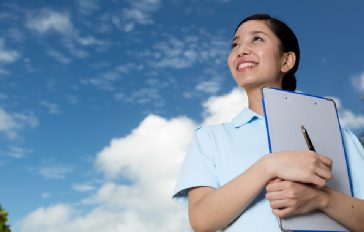 空を見上げる看護師の女性